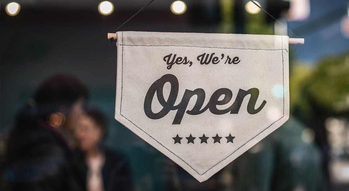 Sign that says "yes, we're open."