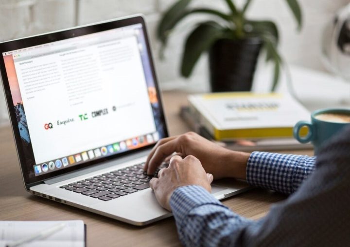 Person sitting at desk and looking at their laptop.