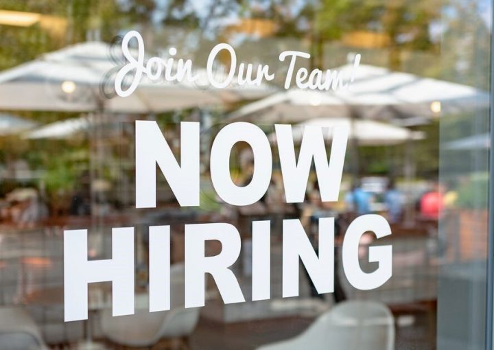 Window with a "now hiring" sign.